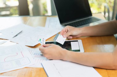 UX veya UI tasarımcıları dijital tablet ve akıllı telefon uygulama düzeni prototip projesi üzerinde tasarım yapıyorlar.