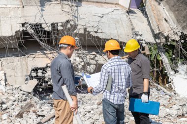 Yıkım kontrol şefi ve müteahhit binayı yıkmayı tartışıyorlar..