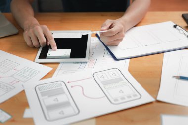 UX veya UI tasarımcıları dijital tablet ve akıllı telefon uygulama düzeni prototip projesi üzerinde tasarım yapıyorlar.