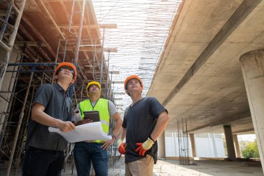 İnşaat işçileri, inşaat alanında proje detaylarını idari amirle tartışıyor..