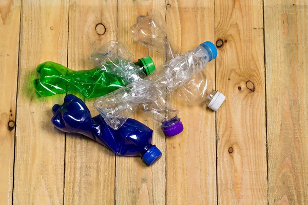 Bouteilles en plastique usagées sur panneau en bois — Photo