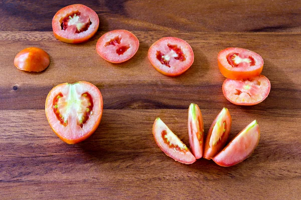 Нарізаний свіжий червоний помідор на дерев'яній дошці — стокове фото