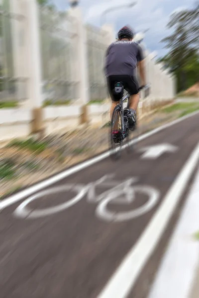 Um homem tem um exercício de andar de bicicleta com borrão de movimento — Fotografia de Stock