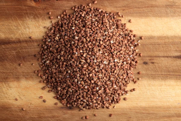 Grains of buckwheat on the kitchen board — Stock Photo, Image