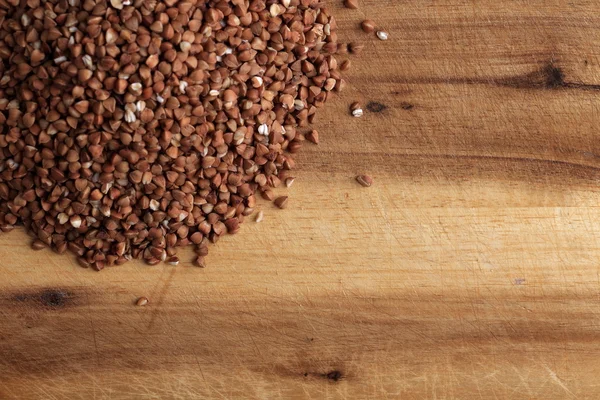 Grains of buckwheat on the kitchen board — Stock Photo, Image