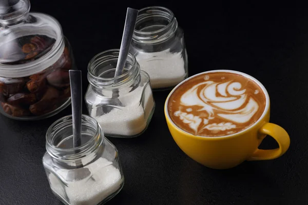 Cup of cappuccino and sugar bowls — Stock Photo, Image