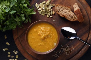 Ahşap tahta üzerinde kabak, mercimek ve havuç çorbası