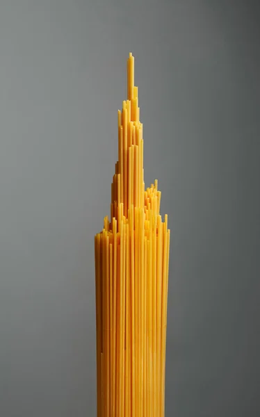 Bos van spaghetti pasta. Grijze achtergrond — Stockfoto