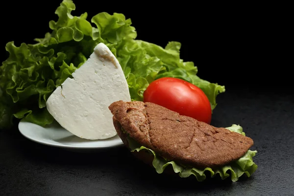 Vegetable and cheese sandwich. Tomato and salad leaves. Dark background — Stock Photo, Image