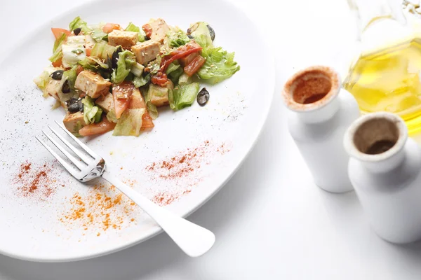 Soya peyniri ve sebze salatası. Zeytinyağı ve baharat. Beyaz arka plan
