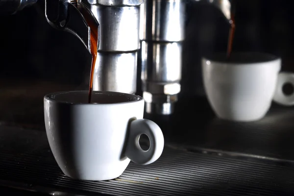 Espressomaskin brygga en kopp kaffe. Hälla i en kopp kaffe. Traditionell italiensk drink närbild med kopia utrymme. — Stockfoto