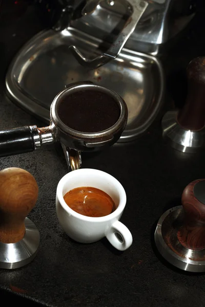 Witte porseleinen kopje koffie en portafilter van een espressomachine — Stockfoto