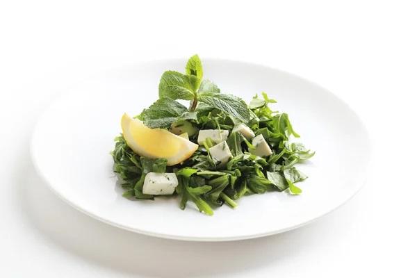 Green salad with cheese, lettuce, mint, rucola and lemon isolated on white — Stock Photo, Image