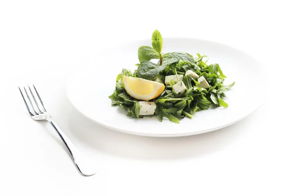 Green salad with cheese, lettuce, mint, rucola and lemon isolated on white — Stock Photo, Image