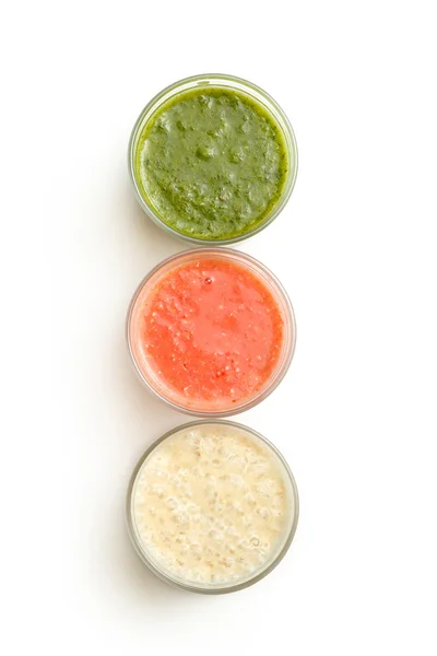 Üç bardak şifalı otlarla, çilek ve muz smoothie beyaz izole