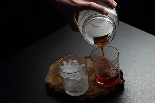 Filtrer kaffe i glass med varm og kald farge på et trebrett på mørk bakgrunn med kopiplass . – stockfoto