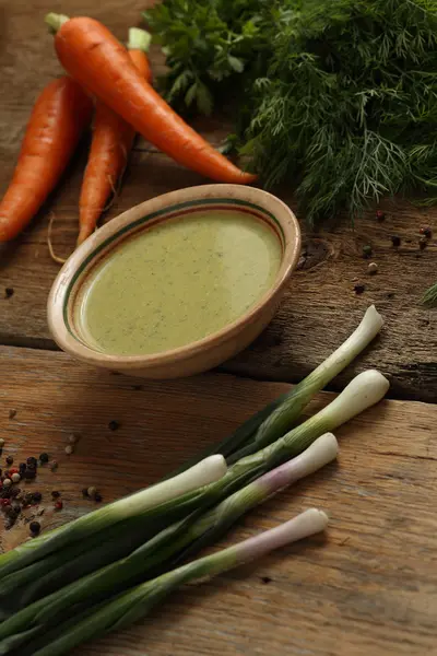 Sopa de ervilha verde em uma tigela de cerâmica, cenouras, cebola e ervas — Fotografia de Stock