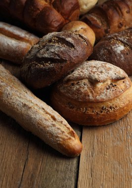 Ahşap arka plan üzerinde ekmek ürün yelpazesine sahip. Taze kopya alanı ile farklı tahıl çeşitli closeup ile pişirme