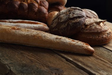Ahşap arka plan üzerinde ekmek ürün yelpazesine sahip. Taze kopya alanı ile farklı tahıl çeşitli closeup ile pişirme