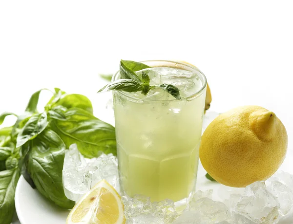 Copo de limonada com folhas de manjericão, limões e cubos de gelo isolados sobre fundo branco — Fotografia de Stock