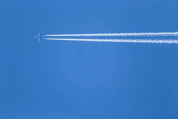 Avión Con Dos Pistas Condensación Cielo Azul Claro — Foto de Stock