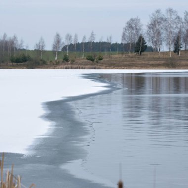 Kış sakin göl manzarası. Dondurucu su hattı. Nehirde eriyen buz.