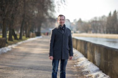 Kış sehpasında gri ceketli gözlüklü bir adamın portresi..