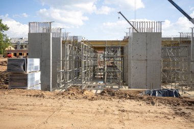 Modern bina yapım halinde. İşçiler beton dökmek için iskele ve yapı iskelesi kurdular.