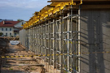 Yeni bir modern binanın inşaatı. Beton dökmek için bir sürü yapı iskelesi ve form..