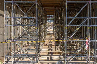 Yeni bir modern binanın inşaatı. Beton dökmek için bir sürü yapı iskelesi ve form..