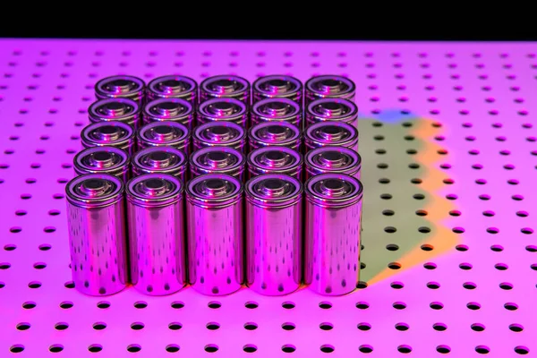 New modern lithium-ion batteries with increased capacity. A prototype of new batteries on a laboratory table illuminated by an ultraviolet lamp.