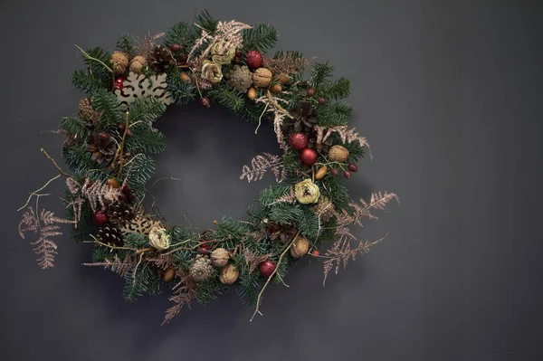 Christmas wreath of vines decorated with fir branches, Christmas balls and natural materials, New Year concept