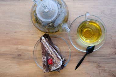 Kafede çay takımlı çikolatalı pasta, cafede servis edilen zarif tatlı, seçici bir odak.