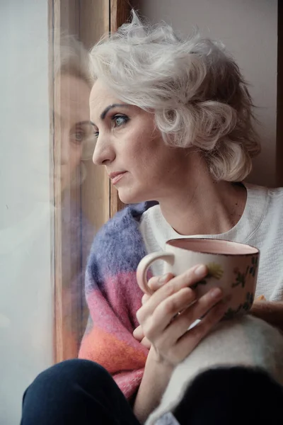 Mujer Madura Pensativa Infeliz Bebiendo Mirando Por Ventana Bloqueo Concepto Imagen de archivo