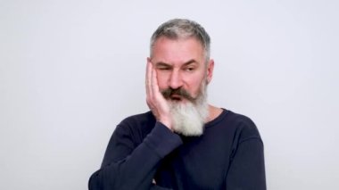 Üzgün, sakallı bir adam başını tutar, alnına vurur, şiddetli depresyon ya da baş ağrısı, beyaz arka plan