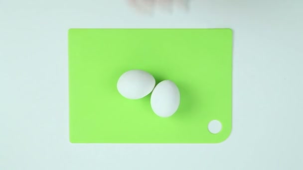 Dos huevos se colocan en el tablero — Vídeo de stock