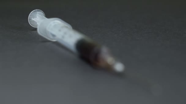 Syringe met de drug. zwarte achtergrond — Stockvideo