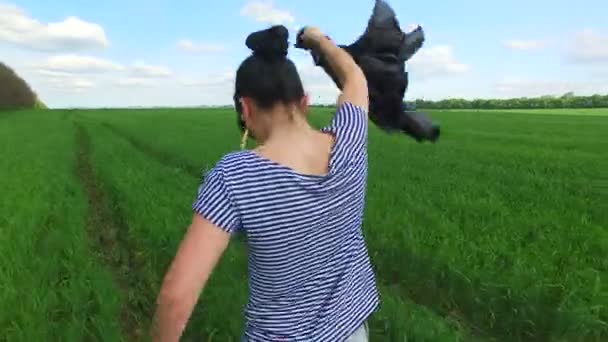 Chica va en un campo verde de trigo — Vídeo de stock