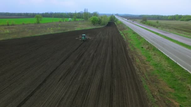 Traktor i ett fält att göra gödsel — Stockvideo