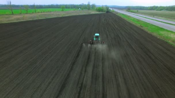 Traktor i ett fält att göra gödsel — Stockvideo