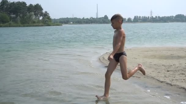 Хлопчик стрибає в озері — стокове відео