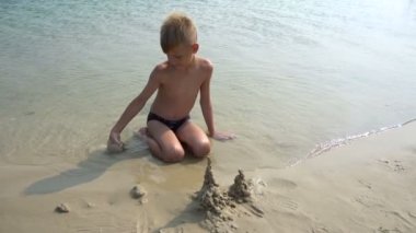 Bir çocuk bir sandcastle oluşturur