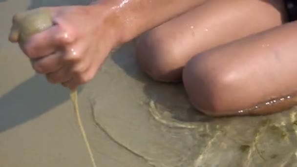 Un garçon construit un château de sable — Video