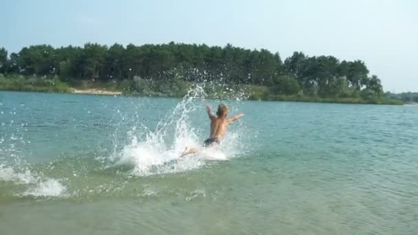 Garçon fait un saut dans le lac — Video