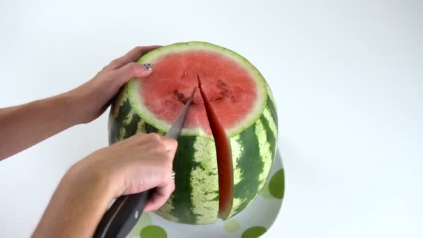 Meisje snijdt een watermeloen — Stockvideo