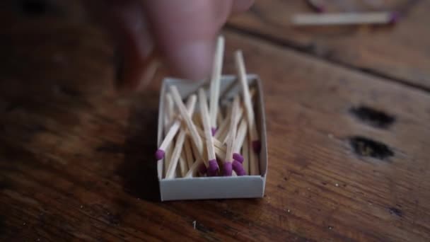 Mujer mayor recogiendo partidos en una caja de cerillas — Vídeo de stock