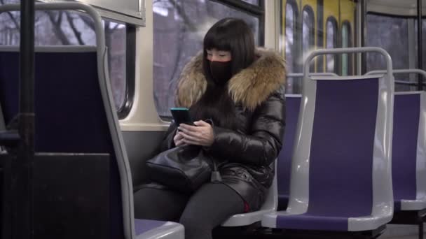 Dívka jezdí tramvají v masce — Stock video