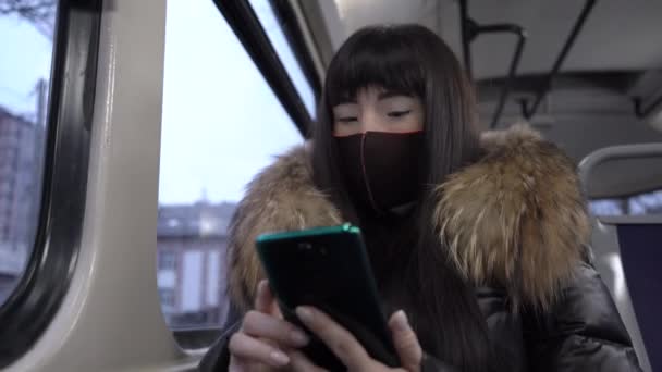 Meisje rijdt in een tram met een masker op — Stockvideo