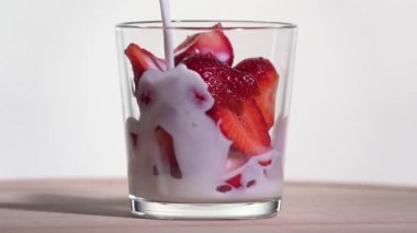 Çileklerin üzerine süt dök. Yavaş çekim 250 fps