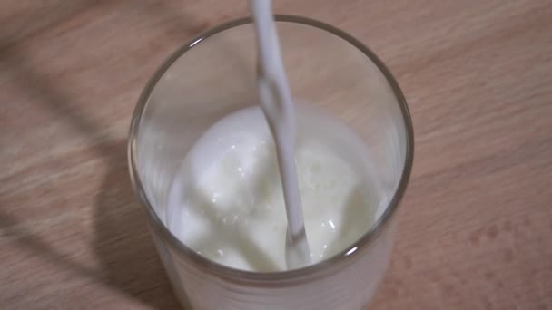 Mjölk hälls i ett glas. Långsamma rörelser 250fps — Stockvideo